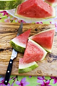 Wedges of watermelon and knife on a wooden board
