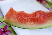 Angebissener Melonenschnitz auf einer Stoffserviette