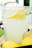 Lemonade in a glass jug with slices of lemon