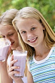 Two girls drinking berry smoothies