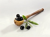 Black olives in a wooden spoon