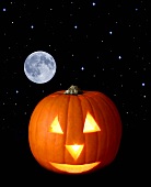 A Halloween pumpkin with moon and stars in background