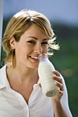 Junge Frau Trinkt Milch aus der Flasche