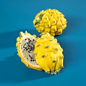 Two yellow pitahayas, whole and halved