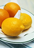 Zwei Zitronen und Orangen auf einem Teller
