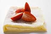 Crêpes with icing sugar and strawberries