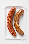 White and red sausages on a paper plate