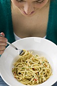 Woman eating spicy pasta dish