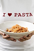 Woman holding pasta plate of spaghetti and tomato sauce