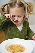 Kleines Mädchen isst Bärchen-Nudel-Suppe