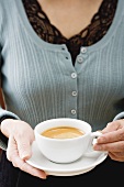 Frau hält eine Tasse Kaffee in den Händen