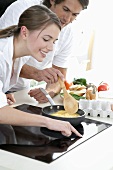 Young couple cooking scrambled eggs