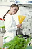 Woman holding a bundle of spaghetti in her hands