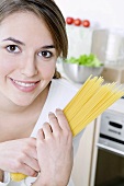 Woman holding a bundle of spaghetti in her hands