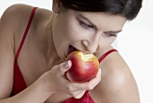 Frau beisst in einem Apfel