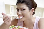 Woman eating fruit yoghurt