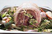 Rolled pork roast with herb stuffing on bed of vegetables