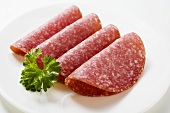 Four slices of salami with parsley
