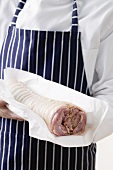 Rolled saddle of suckling pig on greaseproof paper