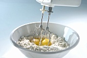 Mixing flour and eggs with an electric hand mixer