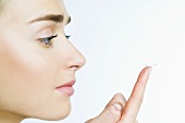 Woman with contact lens on her finger