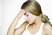 Woman with headache rubbing her forehead