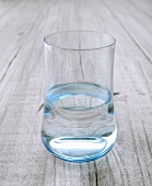 Ein Glas Wasser auf Holzuntergrund