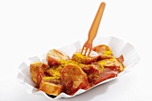A currywurst (sausage with ketchup & curry powder) in paper dish