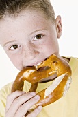 Boy biting into a pretzel