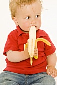 Small boy eating a banana