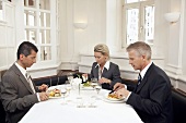 Woman and two men at a business meal
