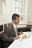 Man sitting in front of plate of salad in a restaurant