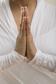 Young woman meditating with hands together