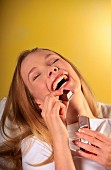 Happy, laughing woman eating bar of chocolate
