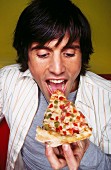 Man eating slice of pizza