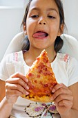 Mädchen mit einem Stück Pizza