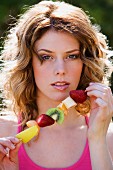 Woman with fruit skewer