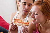 Couple sharing a slice of pizza