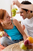 Couple eating fruit in living room