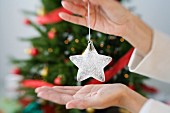 Woman holding star-shaped Christmas decoration