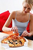 Woman eating pizza out of pizza box