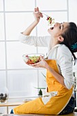 Woman eating lettuce from a bowl of salad