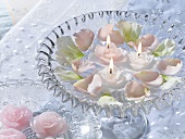 Flowers and floating candles in a glass pedestal dish
