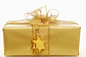 Gift in gold wrapping paper with gold star