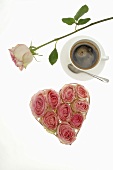 Heart-shaped box full of roses, cup of coffee
