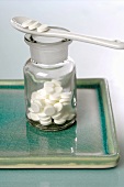 Schüssler Salze: Tabletten im Apothekerglas und auf Löffel
