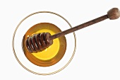 Honey and honey dipper in glass (overhead view)