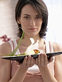 Woman holding metal dish with lily