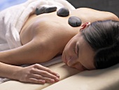 Woman having a warm stone massage