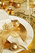 Place-setting with napkin, gold bow and gilded walnut